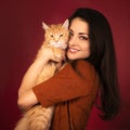 Beautiful happy smiling young woman holding and hugging with love her red maine coon kitten. Closeup portrait Royalty Free Stock Photo