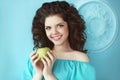 Beautiful happy teen smiling girl holding green apple before the