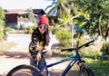 Beautiful happy teenage woman standing with bicycle and relaxing outdoors with a red hat and sunglasses Royalty Free Stock Photo