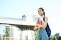 Beautiful happy woman with a backpack going to college. Young female university student with books in campus.