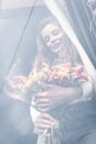 Happy woman with bouquet of autumn flowers behind the window Royalty Free Stock Photo