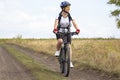 Beautiful and happy woman cyclist rides a bicycle on the road in nature. Healthy lifestyle and sports. Leisure and hobbies