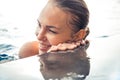 Beautiful happy woman face portrait in swimming pool with water reflections as summer vacation holidays lifestyle