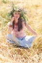 Beautiful happy woman in flower wreath in summer