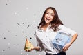 Beautiful happy woman with gift box at celebration party with confetti falling everywhere on her. Royalty Free Stock Photo