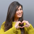 Beautiful happy woman holding heart in hands against gray background Royalty Free Stock Photo