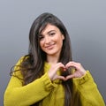 Beautiful happy woman holding heart in hands against gray background Royalty Free Stock Photo