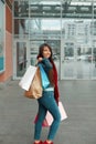 Beautiful happy woman holding shopping bags and smiling near the mall Royalty Free Stock Photo