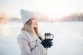 Beautiful happy woman outdoor winter. Laughing girl with hot drink tea or coffee with snowfall Royalty Free Stock Photo