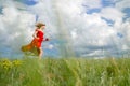 Beautiful happy woman in red dress runs on a green field Royalty Free Stock Photo