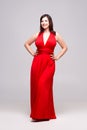 Beautiful happy woman in red dress in studio on gray background Royalty Free Stock Photo