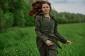 a beautiful, happy woman runs across a green field with flowing red hair. Emotions of happiness Royalty Free Stock Photo