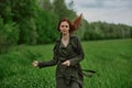 a beautiful, happy woman runs across a green field with flowing red hair. Emotions of happiness Royalty Free Stock Photo