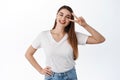 Beautiful happy woman shows peace v-sign and smiles at camera joyful, stay on bright side, being optimistic, standing in Royalty Free Stock Photo