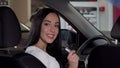 Beautiful happy woman sitting in her new auto, showing car key to the camera Royalty Free Stock Photo