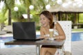 Beautiful happy woman in Summer dress outdoors at nice coffee shop having breakfast networking or working with laptop computer Royalty Free Stock Photo