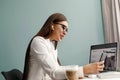 Beautiful happy woman using mobile phone while working at home with laptop. Royalty Free Stock Photo