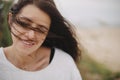 Beautiful happy woman with windy hair portrait on background of sandy beach and grass, carefree tranquil moment. Stylish young Royalty Free Stock Photo