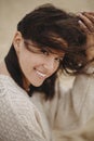 Beautiful happy woman with windy hair portrait on background of sandy beach and sea, carefree tranquil moment. Stylish young Royalty Free Stock Photo