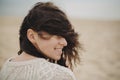 Beautiful happy woman with windy hair portrait on background of sandy beach and sea, carefree tranquil moment. Stylish young Royalty Free Stock Photo