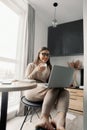 Beautiful happy woman working at home with laptop taking cup of coffee . Smiling business woman woman wearing eyeglasses in office Royalty Free Stock Photo