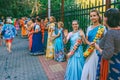 Beautiful and happy women and girls are hare Krishna in bright dresses dancing and singing on the streets of Sochi in the summer