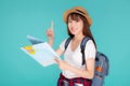 Beautiful happy young asian woman travel holding and looking a paper map isolated on blue background