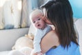 Beautiful happy young brunette woman gracing her newborn baby in Royalty Free Stock Photo