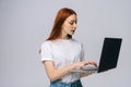 Beautiful happy young business woman or student holding laptop computer and looking at screen. Royalty Free Stock Photo