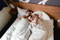 Beautiful happy young couple or family waking up together in bed Royalty Free Stock Photo
