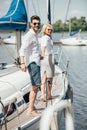 beautiful happy young couple in sunglasses holding hands and smiling at camera Royalty Free Stock Photo