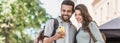 Beautiful happy young couple using smartphone outdoors panoramic banner. Joyful smiling woman and man looking at mobile phone in a Royalty Free Stock Photo