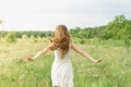 Beautiful and happy young girl running on the green field in a white dress. Royalty Free Stock Photo