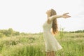 Beautiful and happy young girl running on the green field in a white dress. Royalty Free Stock Photo