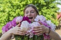 Beautiful and happy young girl in the summer with a beautiful bouquet of peonies in nature Royalty Free Stock Photo