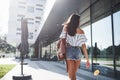 Beautiful, happy young student girl with backpack near the campus of university. Education and leisure concept