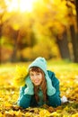 Beautiful happy young woman in the autumn park. Joyful woman wearing bright teal hat and scarf is having fun outdoors in a bright