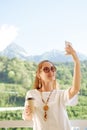 Woman taking selfie on background of summer mountains. Royalty Free Stock Photo