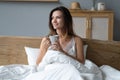 Beautiful Happy Young Woman Drinking Cup Of Coffee Or Tea While Lying In Bed After Waking Up In Morning Royalty Free Stock Photo