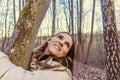 Beautiful happy young woman embracing the tree in the forest at sunset in spring Royalty Free Stock Photo