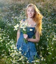 The beautiful happy young woman in the field of camomiles.Portrait in a sunny day Royalty Free Stock Photo