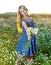 The beautiful happy young woman in the field of camomiles Royalty Free Stock Photo