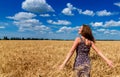 Beautiful happy young woman in golden wheat field with cloudy. Royalty Free Stock Photo