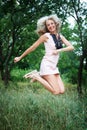 Beautiful happy young woman jumping high in air in the park Royalty Free Stock Photo