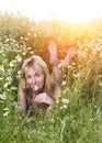 Beautiful happy young woman lies in the field of camomiles Royalty Free Stock Photo