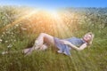 The beautiful happy young woman lies in the field of camomiles Royalty Free Stock Photo