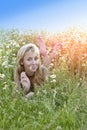 The beautiful happy young woman lies in the field of camomiles Royalty Free Stock Photo