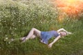 The beautiful happy young woman lies in the field of camomiles Royalty Free Stock Photo