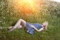 The beautiful happy young woman lies in the field of camomiles Royalty Free Stock Photo