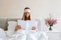 Beautiful Happy Young Woman reading lifestyle magazine While Lying In Bed After Waking Up In Morning. Portrait Of Royalty Free Stock Photo